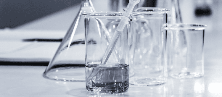 Pipette in beaker full of water that's about to be tested for water hygiene services