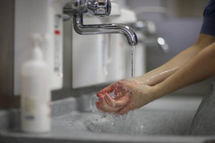 A close up of a person washing their hands