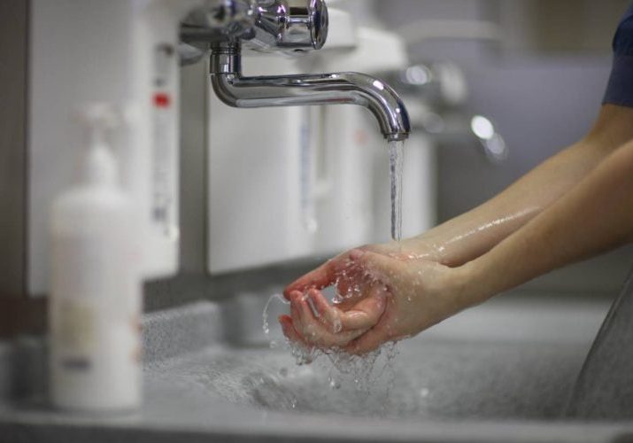 A close up of a person washing their hands
